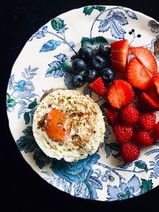 Vibrant breakfast plate featuring an egg and a mix of fresh berries for a healthy start.